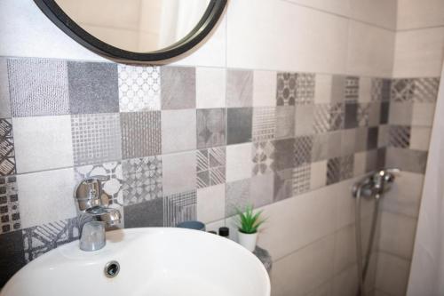 a bathroom with a sink and a mirror at Τοτα Μαρινου in Trikovilón