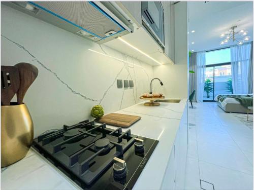 een keuken met een kookplaat in de kamer bij Luxury New Studio with Pool & Gym Access, 5 min from Gardens Metro in Dubai