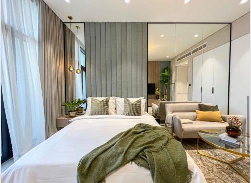 een slaapkamer met een groot bed en een woonkamer bij Luxury New Studio with Pool & Gym Access, 5 min from Gardens Metro in Dubai