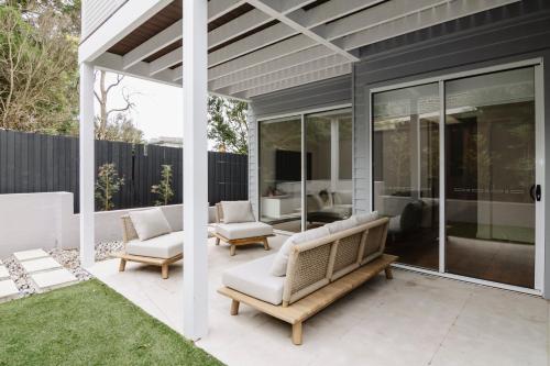 a patio with couches and chairs on a house at Beachside Mornington house in Mornington