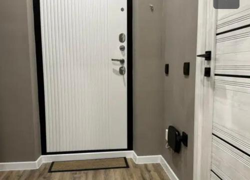 ein Bad mit einer Tür mit einem Spiegel und Holzböden in der Unterkunft VIP apart 789 in Tbilisi City