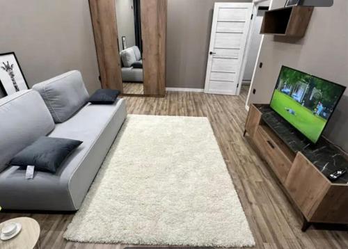 ein Wohnzimmer mit einem Sofa und einem Flachbild-TV in der Unterkunft VIP apart 789 in Tbilisi City