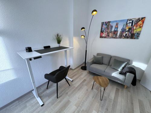 a living room with a table and a couch at Modernes Apartment in top Lage komfortabel eingerichtet mit Arbeitsplatz und Küche - Geibelsuite in Hannover