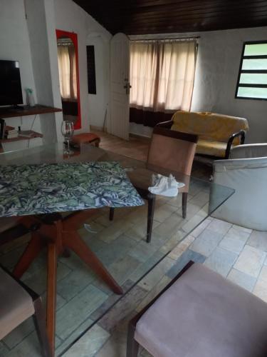 uma sala de estar com uma mesa e um sofá em CASA DE PRAIA em São Sebastião