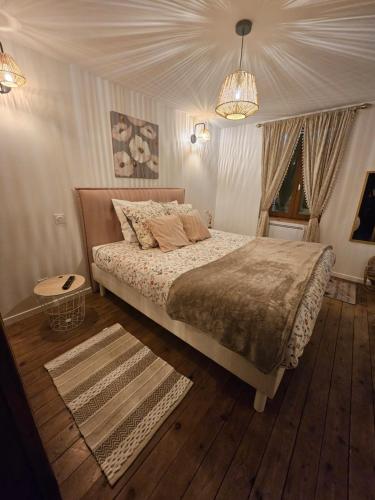 une chambre avec un lit et un lustre dans l'établissement Gite le Montinho, à Fontevraud-l'Abbaye