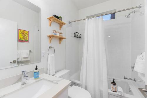 a white bathroom with a sink and a shower at Calm Urban Abode steps to Volunteer Park in Seattle