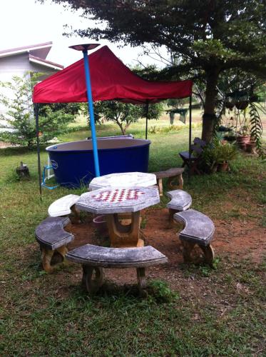 a picnic table with a red tent in a park at Paradise Hill in Chiang Dao