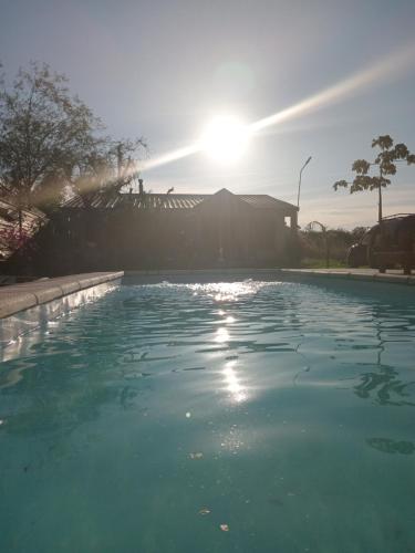 a pool of water with the sun in the background at Casa de Campo La Amada in Federación