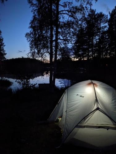 a tent sitting in the grass next to a lake at Rämsbyns Fritidsby in Rämshyttan