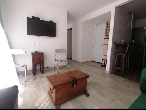 a living room with a tv and a wooden box at Comodidad y tranquilidad in Ibagué