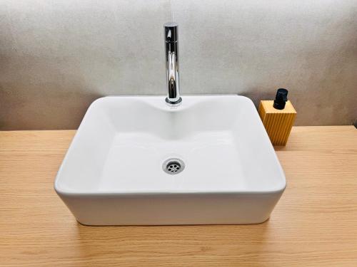 a white sink sitting on top of a wooden table at Smrek Apartments in Oravská Lesná