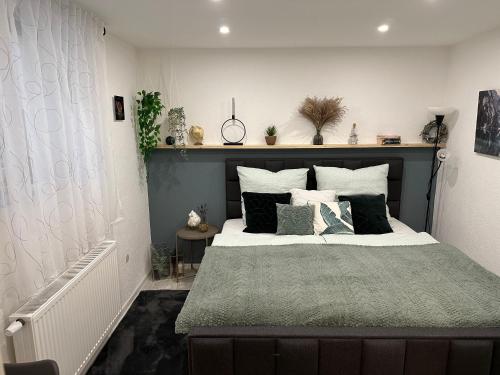 1 dormitorio con 1 cama grande con almohadas blancas y negras en Moderne ruhige Ferienwohnung en Ubstadt-Weiher