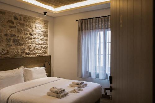 a bedroom with a bed with two towels on it at Μikri Arktos Boutique Hotel in Dimitsana