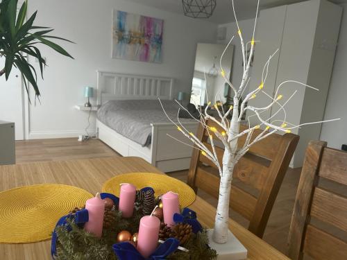 a dining room with a table with a tree and candles at Ecology North London Studios in East Barnet