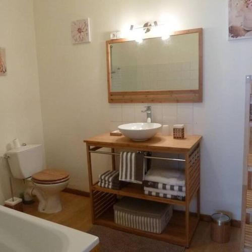 une salle de bain avec un lavabo, des toilettes et un miroir dans l'établissement Les Aigrettes, en plein centre, à 200m de la plage, à Saint-Vaast-la-Hougue