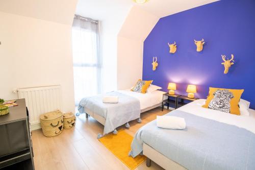 1 dormitorio con 2 camas y pared azul en Villa Greux - 6 personnes - New, en Montlouis-sur-Loire