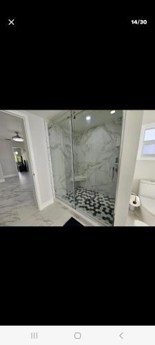 a bathroom with a glass shower with a toilet at Villa hermosa in Key Largo