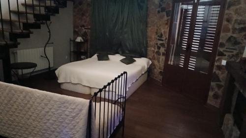 La Codosera的住宿－卡米諾德爾阿連特茹農家樂，一间带两张床的卧室,位于一个设有楼梯的房间