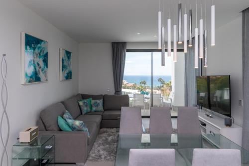 salon z kanapą i szklanym stołem w obiekcie Luxury 2BR Seaviews - Santa Barbara Heights w mieście Fuengirola