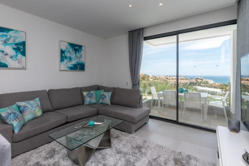 a living room with a couch and a view of the ocean at Luxury 2BR Seaviews - Santa Barbara Heights in Fuengirola