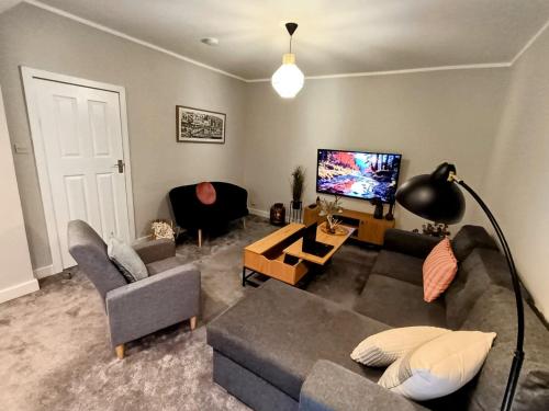 a living room with a couch and a tv at The Tansley Gardens in Darlington