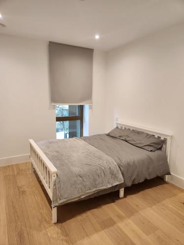 a bed in a white room with a window at Stunning 2-Bed Apartment in Brentford in Brentford