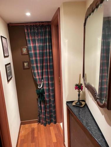a hallway with a plaid curtain and a mirror at Torre delle rondini in Castelnuovo di Farfa