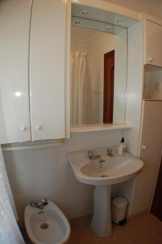 een badkamer met een wastafel, een toilet en een spiegel bij Apartamento La Luz de Reinosa 1 in Reinosa