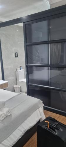 a bedroom with a bed and a black book shelf at Caribbean Estates Villa Raiya- First choice !!! 4 bedrooms with ensuite bathrooms in Port Edward