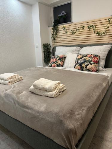 ein großes Bett mit zwei Kissen darüber in der Unterkunft Moderne ruhige Ferienwohnung in Ubstadt-Weiher