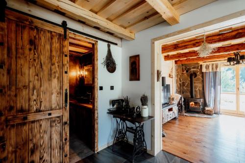 a room with a wooden door and a table at Oskarówka domek w górach na odludziu z jacuzzi i sauną - kominek i Netflix in Szczawa
