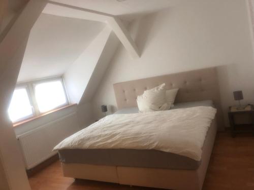 - une chambre avec un lit blanc et 2 fenêtres dans l'établissement Südbahnhof, à Marbourg