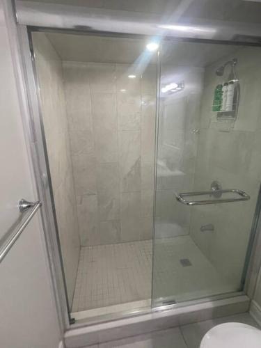 a glass shower in a bathroom with a toilet at Zen Nest in Brampton