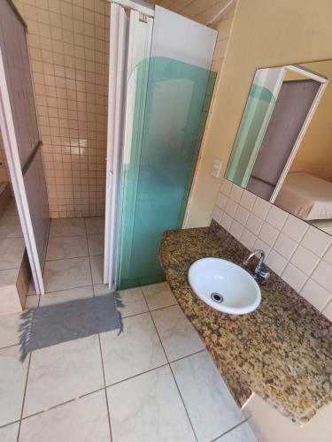 a bathroom with a sink and a shower at Hotel Mar de Minas in Três Marias