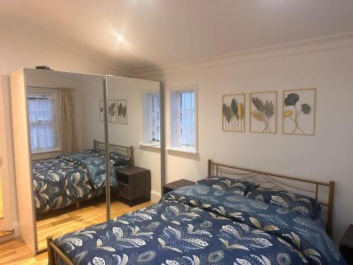 sypialnia z 2 łóżkami i lustrem w obiekcie Cosy home in Greenwich w Londynie