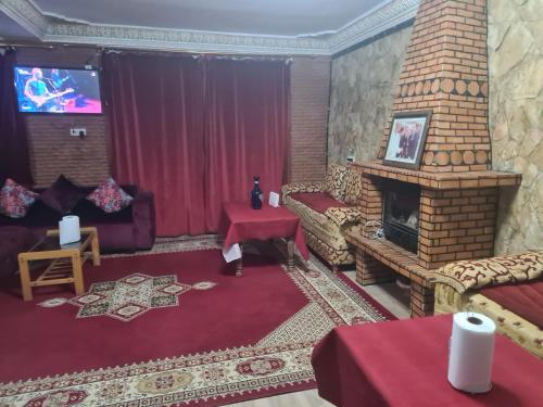 a living room with a couch and a fireplace at Auberge belle vue itto A Station de sevice ZIZ in Aït nʼTaleb Akka