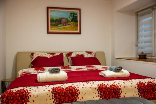 a bedroom with a large bed with red pillows at Guest House Lejla in Travnik