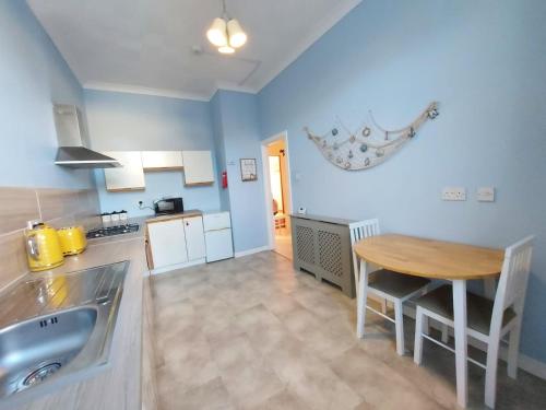 a kitchen with a sink and a table in it at The Octopus - at Largs Town Centre with Private Parking in Largs
