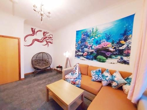 a living room with an orange couch and an aquarium painting at The Octopus - at Largs Town Centre with Private Parking in Largs