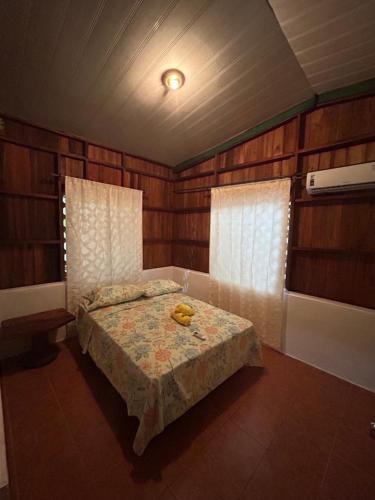 sypialnia z łóżkiem w pokoju z drewnianymi ścianami w obiekcie Casa Oasis de Ballenas w mieście Uvita