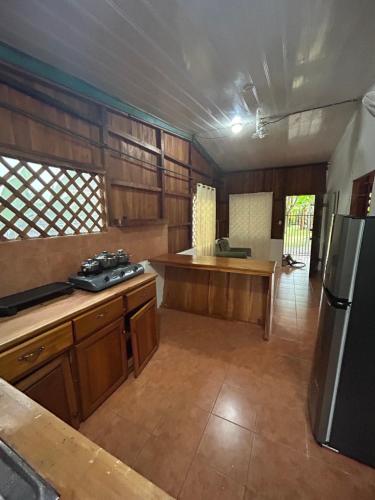 duża kuchnia z drewnianymi szafkami i lodówką w obiekcie Casa Oasis de Ballenas w mieście Uvita