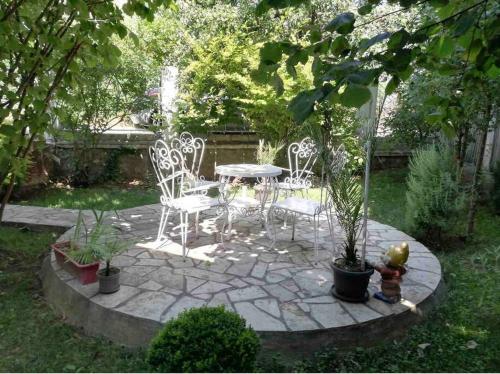 un patio con una mesa, sillas y una fuente. en Smeštaj Milinković, en Kovanluk