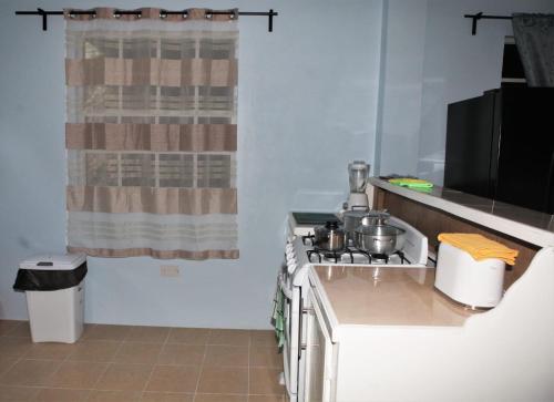 a kitchen with a stove with pots and pans on it at Paradise Apartment in Castries