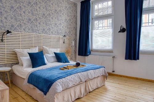 um quarto com uma cama grande e almofadas azuis em No.1 by 21Apartments em Krefeld