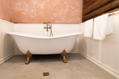 uma banheira branca na casa de banho com toalhas em Loo kodu&köök em Muraste