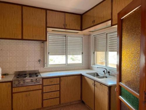 a kitchen with a sink and a stove and windows at Departamento muy amplio, 3 habitaciones, 2 baños! in Junín