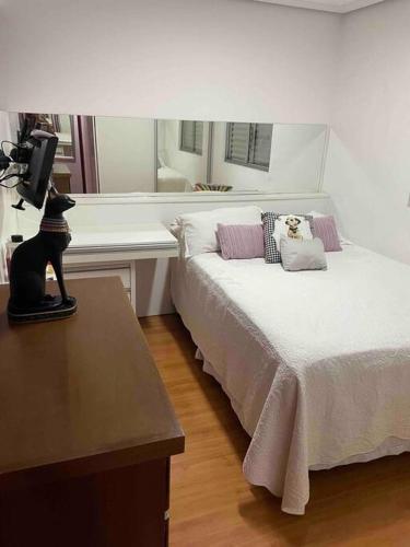 a bedroom with a bed with a cat statue on a table at Cobertura incrível, com jacuzzi e churrasqueira. in Belo Horizonte