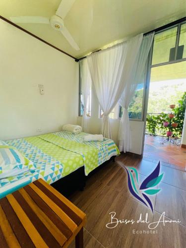 a bedroom with two beds and a window at EcoHotel Brisas del Amani in Norcasia