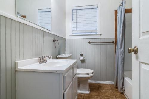 Baño blanco con lavabo y aseo en Jefferson Rental Room 1, en Lafayette