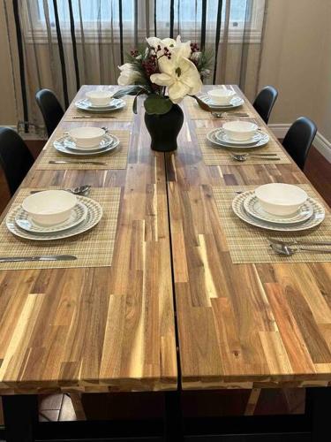 a wooden table with plates and a vase of flowers on it at Vacation paradise in St. Catharines